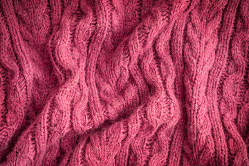 Background made of top view of crumpled surface texture of casual comfortable woven handmade textile material knitted from wool, merino or cashmere soft warm yarn of dark purple colour used for cloth