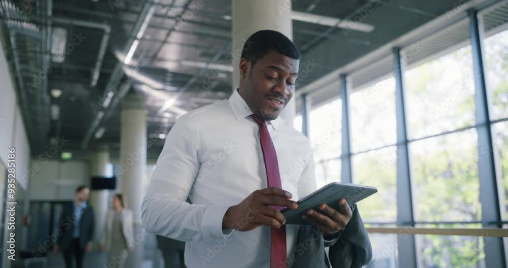 Poster African Businessman Walking in a Modern Office Building, Using a Tablet Computer for Work. Successful Manager Communicating Online, Browsing Company Software Data and Reading Emails
