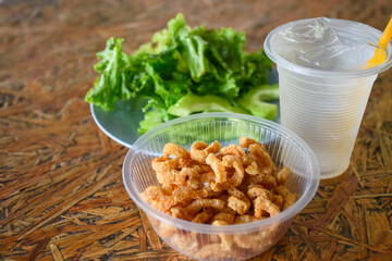 Pork rind with vegetable and drinking glass, Pork snack, Pork scratching or crackling in bowl on...