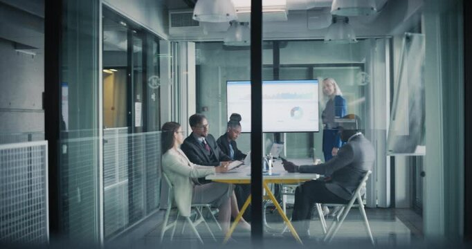 Female Manager Making a Presentation to a Board of Directors in a Meeting Room in the Office. Young Executive Using a Digital Interactive Whiteboard to Show Company Performance, Sales and Revenue Data