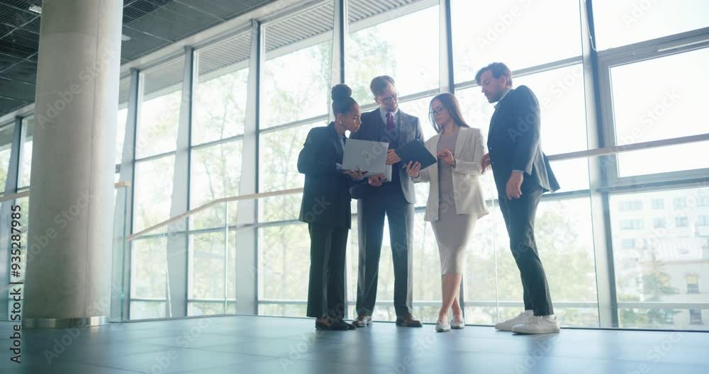 Aufkleber diverse business team engaged in a collaborative discussion in a modern hallway with windows, utiliz