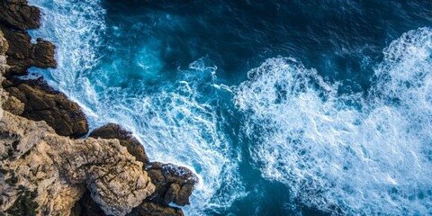 Obraz premium Aerial View of Ocean Waves Crashing Against Rocky Coastline.