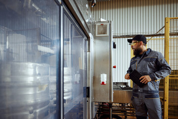 Brewery technologist, in full protective gear, carefully inspecting the production area, highlighting importance of safety and quality. Concept of beer, brewery, manufacture, quality control