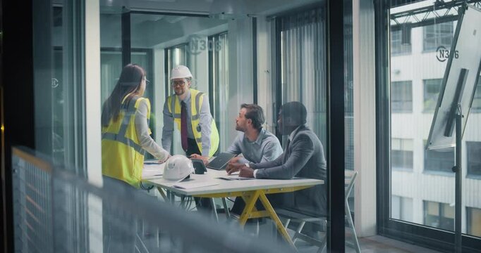 Female and Male Industrial Engineers Having a Business Meeting with a Corporate Manager and an Accountant. Architects Showing Construction Plans, Discussing a Funding for Their Skyscraper Project