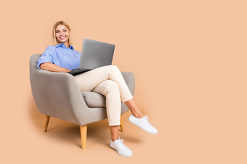 Full length photo of adorable lovely girl wear blue shirt communicating modern device empty space isolated beige color background