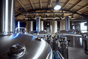 Rows of industrial brewing tanks stand ready, reflecting the advanced equipment used in crafting high-quality beer. Concept of beer, brewery, manufacture, quality control