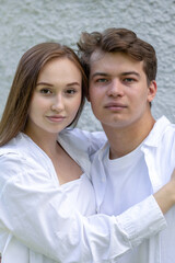 Close-up portrait of couple in love. Young woman and men against gray wall. Vertical photo. High quality photo