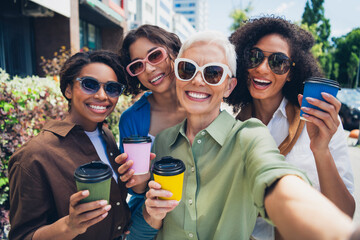 Portrait of company friends women hold coffee make selfie free time street cafe table outdoors