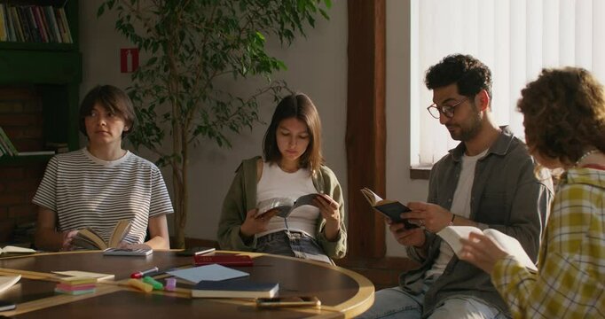 Men flip through the pages of their Bibles while sitting at a table indoors. The Bible Study Club. Daylight