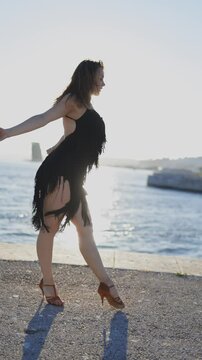 Woman performing salsa dance routine at sunset