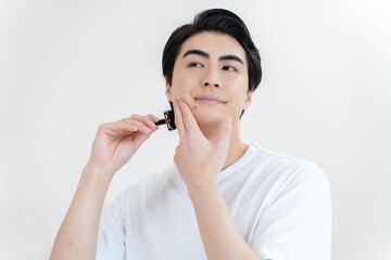 カミソリで顔を剃る日本人男性