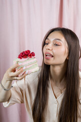 A woman is eating a cake with raspberries on it