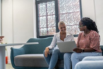 	
On the college campus, two diverse students sit side by side, engrossed in their laptops. Their...