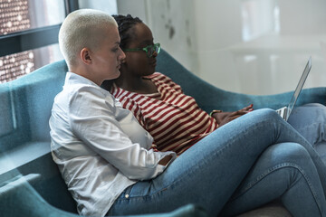 	
On the college campus, two diverse students sit side by side, engrossed in their laptops. Their...
