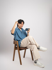Portrait of young Asian business man sitting in chair, isolated on white background