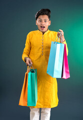 Indian traditional Young handsome man holding and posing with shopping bags on a dark background