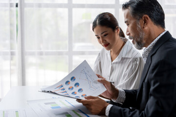 A man and a woman are looking at a set of graphs