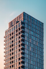 Fototapeta premium The intricate architecture of a distant skyscraper, standing out sharply against a soft blue sky