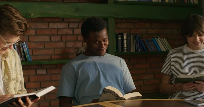 Bible Study Group. Young people read and discuss what they read while sitting at a table indoors. daylight