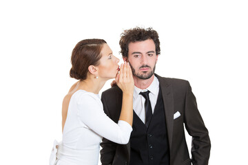 Closeup portrait couple young lovers share secrets, amazed man listening gossip in the ear, unexpected turn of events isolated white background