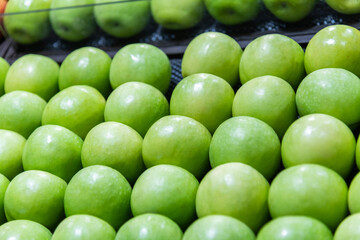 Fresh green apples arranged neatly in the supermarket