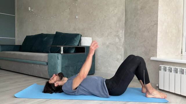 Young man practicing various yoga poses on a blue exercise mat in a bright living room filled with natural light
