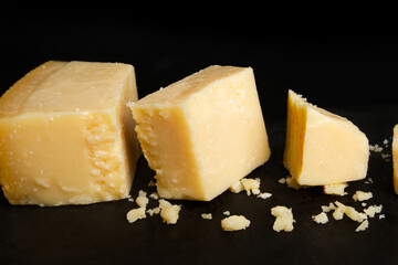 Sliced ​​parmesan cheese on black background.