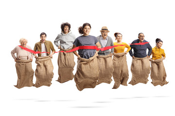 Group of young and older people in sacks at the finsih line of a race