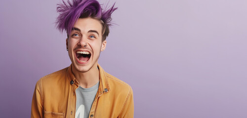 Nonbinary person with vibrant purple hair smiling broadly and wearing a yellow jacket over a gray shirt against a light purple background. The expression on their face is one of excitement and joy.