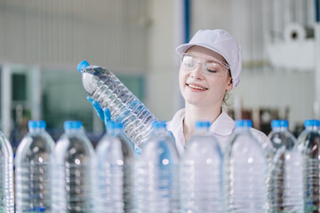 Happy young women worker quality control in Drinking water factory. Production line inspector drink...