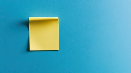 Minimalist blue background featuring a single yellow sticky note, perfectly placed and slightly curled