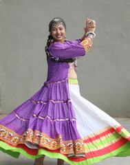 Fototapeta premium girl wearing chaniya choli, banjara shrug and playing garba in navratri. skirt full flare is rotating in the air round. wearing oxidized jewellery and long braid. Indian traditional garba dancer