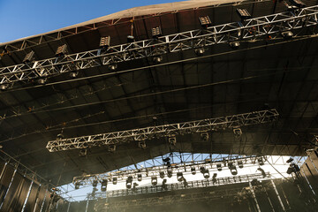 Design of spotlights hanging from rigging on the ceiling of the stage at a music festival