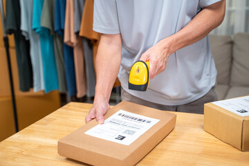 close up hands of an online seller scanning product barcoad on his product box