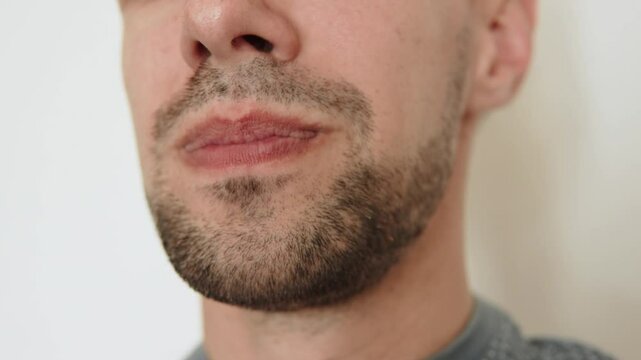 European man sticking his tongue out and in close up. Mouth of person teasing and performing mouth exercises.