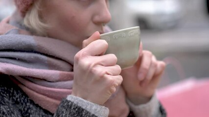 Woman enjoying hot beverage on christmas market in slow motion