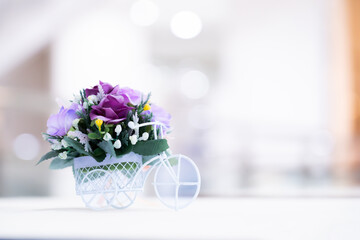 Flower arrangement with white bicycle and colorful flowers, bokeh light background