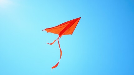 A red kite flying against a clear blue sky, symbolizing freedom and joy