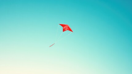 A red kite flying high in a clear blue sky, symbolizing freedom and joy