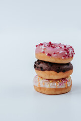 Three donuts in a stack lie on a white background