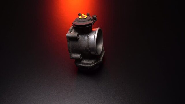 an old throttle for an injection car in a dark room spins in red light