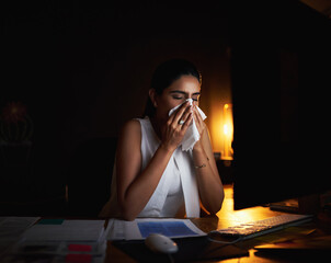 Woman, sick and tissue at night in office for flu virus, allergies problem and medical crisis of wellness. Female person, document and sneeze for bacteria, overtime and infection of deadline pressure