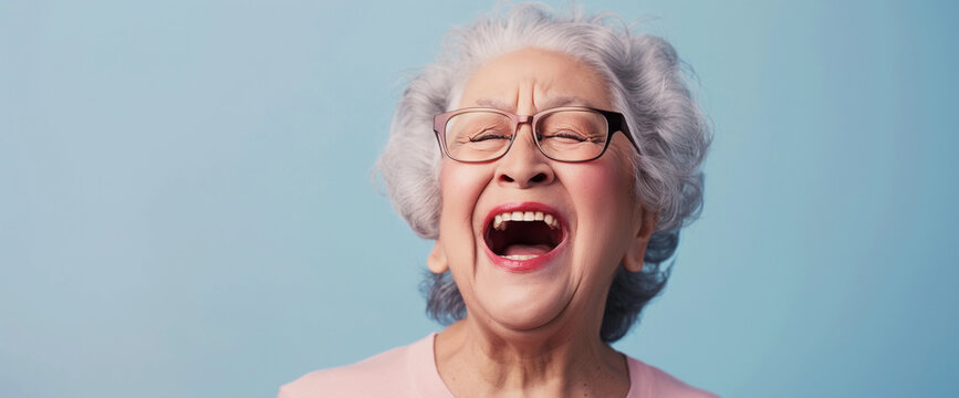 Elderly Asian grandma laughing, blue background
