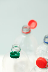 Attached lids on PET bottles on monochrome background