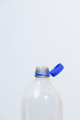 Attached lids on PET bottles on monochrome background