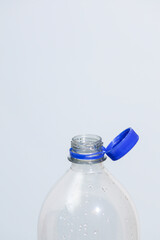 Attached lids on PET bottles on monochrome background