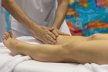 Massage therapist makes relaxing leg massage