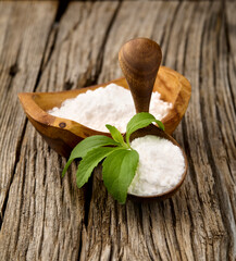 Stevia rebaudiana, sweet leaf sugar substitute isolated in wooden bowl on wooden background