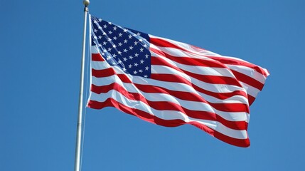Obraz premium American flag blowing in the wind, clear sky