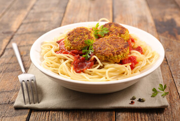 bowl of spashetti with fried zucchini ball and tomato sauce